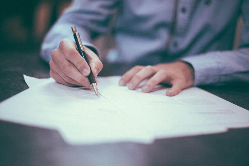 Person signing personal injury settlement paperwork